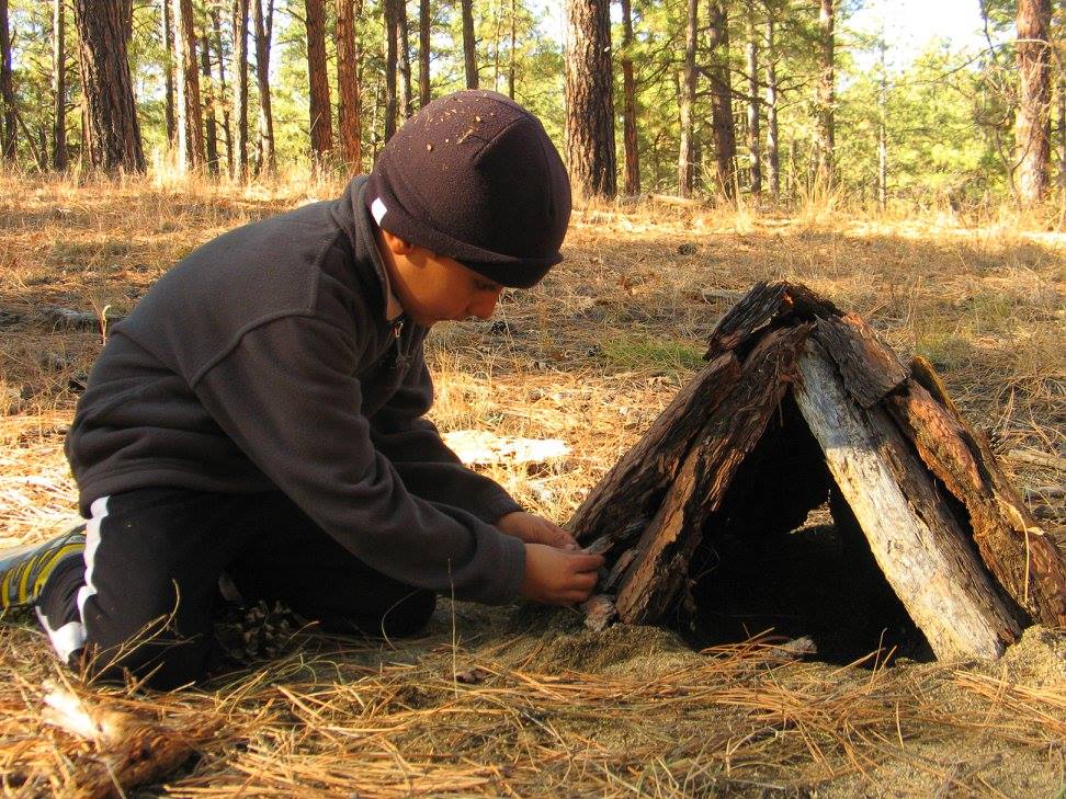 child building a small bark hut